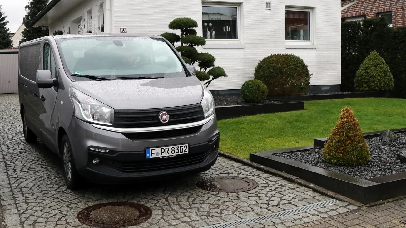 Frontansicht des silbernen Fiat Talento Kastenwagen SX in einer Einfahrt neben einem Haus parkend.